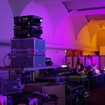 Technical equipment, staff working in the background in a colorful purple-lighted room