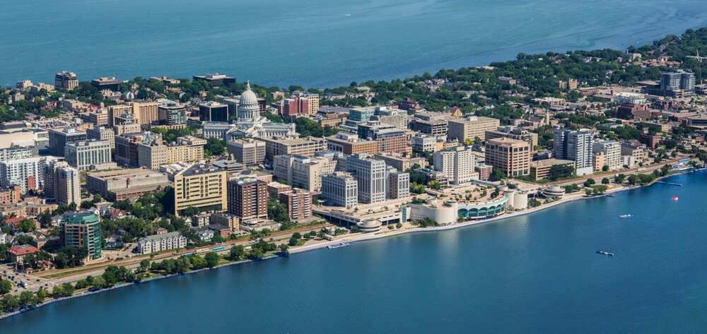 Aerial view of Madison with Lake Monona, city buildings stacked together and Monona Terrace standing out on the lakeshore