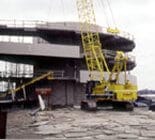 A yellow construction machinery working on Monona Terrace building under construction