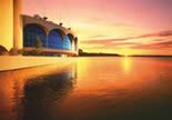 1997 A distant view of the Monona Terrace building from the lake at sunset, yellow and orange colored sky and water
