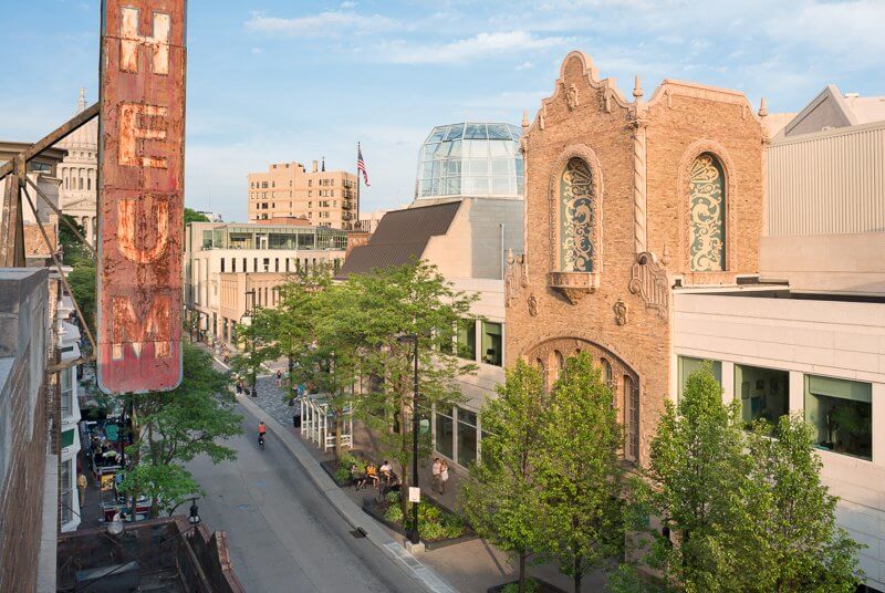 A street photograph taken by Zane Williams in Madison with buildings, trees and an old sign