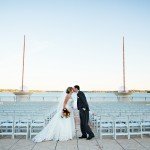 happy married couple standing in front of a pier