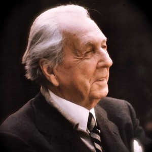 A picture of Frank Lloyd Wright smiling in a suit and tie