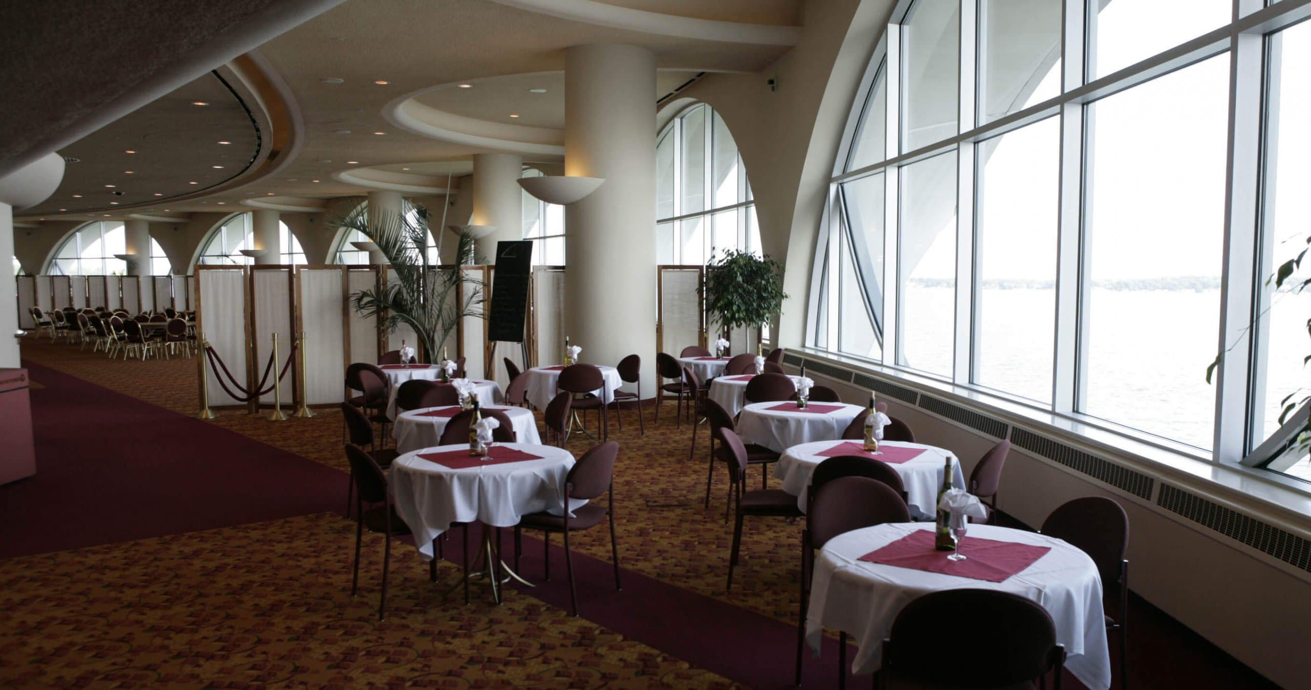 _H2T0248 GrandView Café, round tables with white tablecloths and red chairs by the window, dining hall separated by paravans