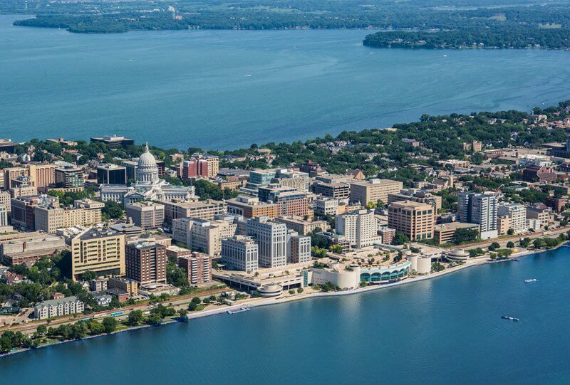 Aerial view of Madison with Lake Monona, city buildings stacked together and Monona Terrace standing out on the lakeshore