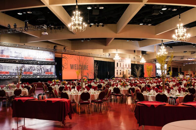 Monona Terrace large event room with round tables, coffee stations and big presentation screens