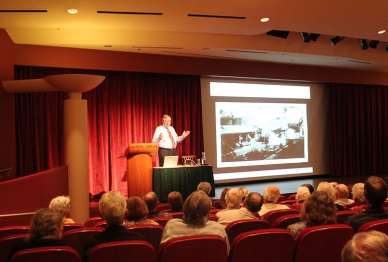 a man presenting in front of people in a room