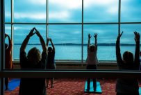 Far view of a yoga studio overlooking the lake with participants having a class