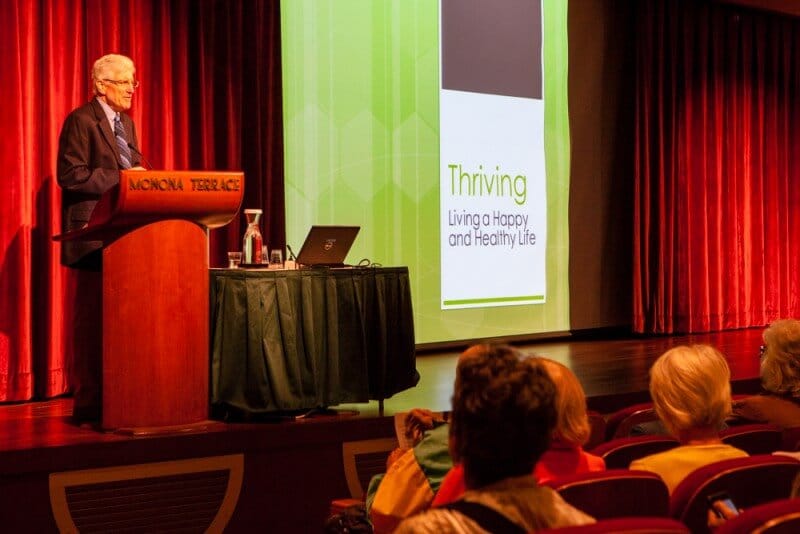 a man presenting in front of a crowd