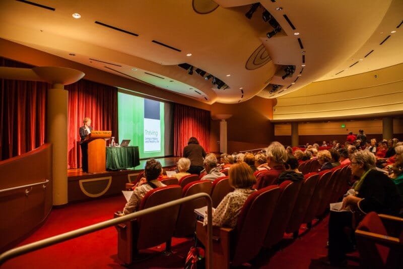 group of people in a room watching presentation