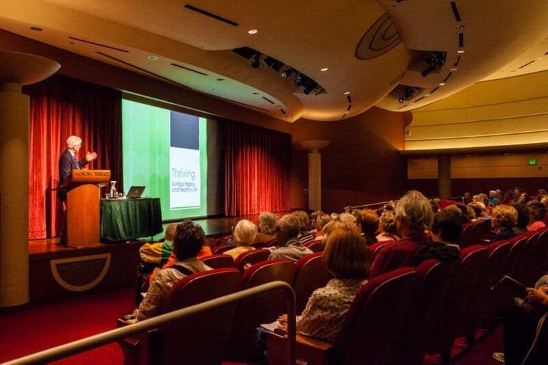 group of people in a room watching presentation