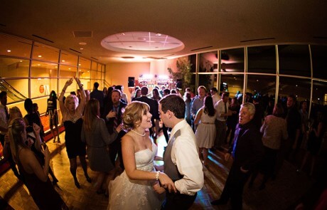 A newlywed couple and guests dancing in a venue