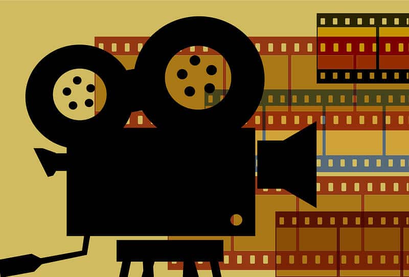 A black sketch of an old school movie camera on a stand with reels on top and a yellow background with colored film rolls