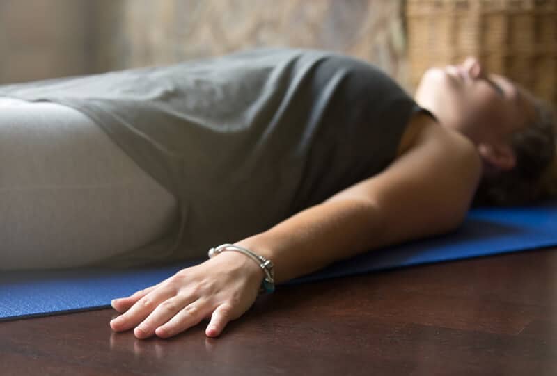 woman laying down on yoga mat relieving stress of the day