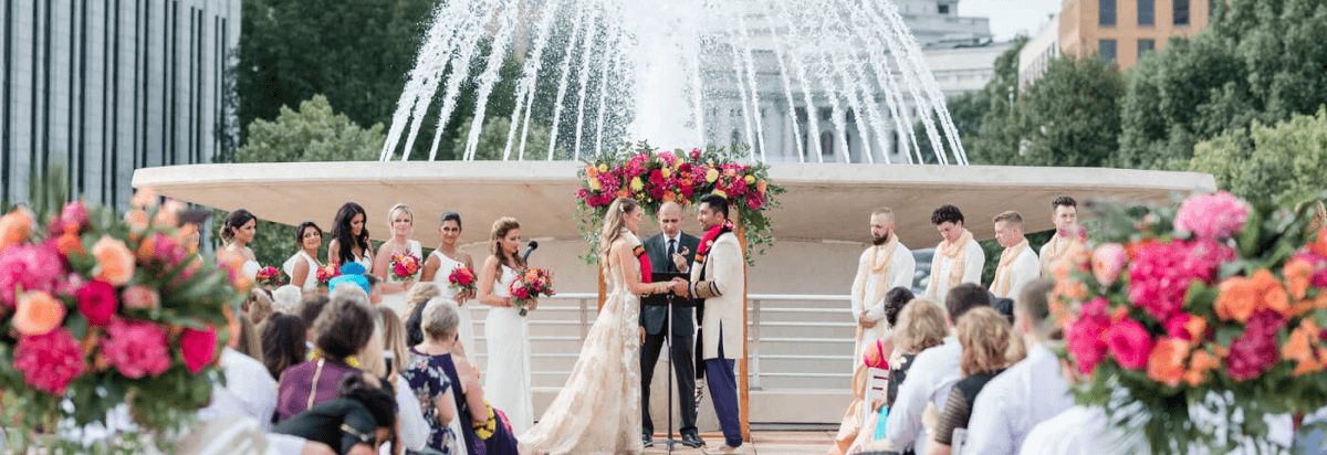 couple getting married in front of a fountain