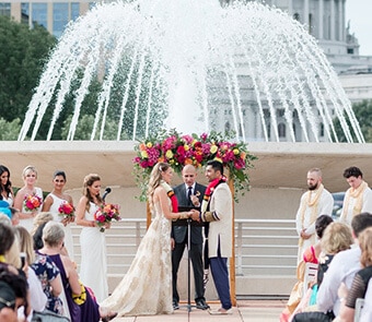 Couple getting married with a fountain in the background