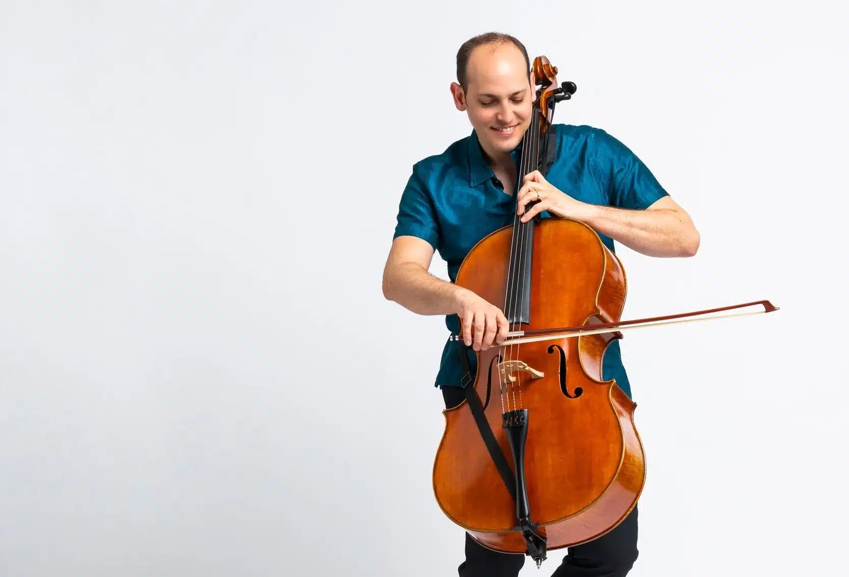 Block on Chello_TileImage Mike Block passionately plays the cello against a white background, conveying a sense of joy and concentration while performing music.